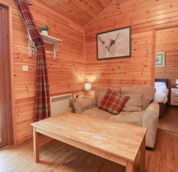 A wooden room with a beige sofa and a wooden coffee table at Chalet Lodge Bunks L1 in Combe Martin