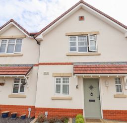 The exterior of a semi detached house with red brick and white walls at 6 Cwrt Griffiths in Prestatyn