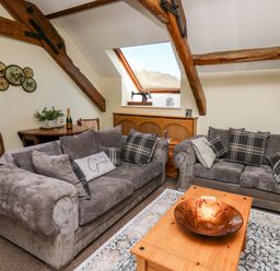 A living room with two sofas and a wooden coffee table under a skylight window at The Cheese Loft in White Mill near Carmarthen