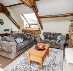 A living room with two grey sofas and a wooden coffee table under a skylight at The Cheese Loft in White Mill near Carmarthen