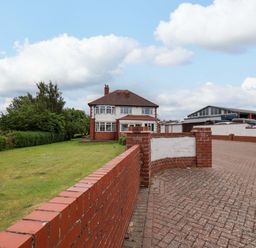 A house with a lawn and garage at Hazelgarth House in Hunmanby