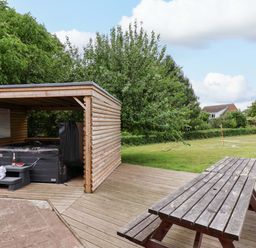 A wooden shelter with a hot tub in the garden of Hazelgarth House, Hunmanby