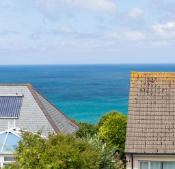 View of the ocean with roofs of houses and greenery in the foreground at Spernenwyn in St Ives
