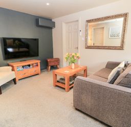 A living room with a sofa and television at Well Cottage Nr Malmesbury