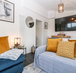 A living room with two sofas and a large wall mounted television at Pennant Cottage in Llithfaen