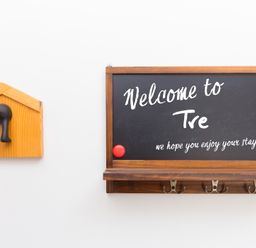 A welcome sign and decorative hooks in the entryway at Carines Barns - Tre