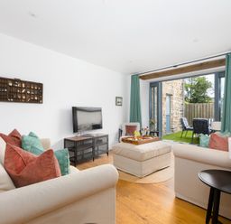 A living room with a television and soft seating area at Carines Barns - Pen, Cubert