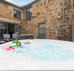 A hot tub with accessories and seating at Carines Barns - Pen, Cubert