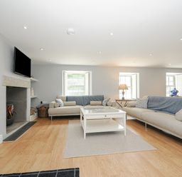 A living room with two sofas a coffee table a fireplace and a television at Cob Cottage near Rock