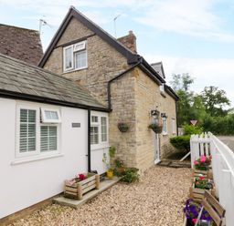 An exterior view of a cottage with garden features at The Cottage in Ettington