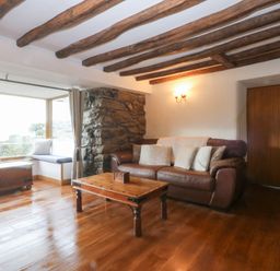 A living room with a sofa and coffee table at Ty'n-Y-Ffynnon Cottage in Barmouth