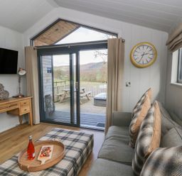 A living room with a sofa and television at Fawn’s Rest Nantmel near Rhayader
