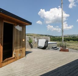 An outdoor space with a sauna and hot tub at Tin Shed Nantmel near Rhayader