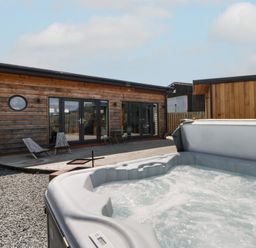 An outdoor area with a hot tub and wooden building at Tin Shed in Nantmel near Rhayader