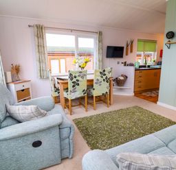 A living room with a dining area and kitchen at Daffodil Lodge Mullacott near Ilfracombe
