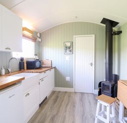 A kitchen with cabinets and a stove at Cuckoo at Wild Valley Huts in Llanrhaeadr-Ym-Mochnant