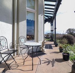 An outdoor patio with metal chairs and tables and potted plants at Ismay Dining Room Suite - Titanic Interest in Waterloo Merseyside