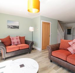 A living room with two sofas and a round white table at Rose Lodge in High Newton-by-the-Sea near Embleton