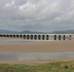 A long bridge over a river with sandy banks and grassy foreground at Walkers Rest in Warton near Carnforth