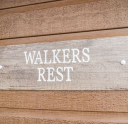 A wooden sign with the words Walkers Rest mounted on a wooden wall at Walkers Rest in Warton near Carnforth