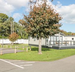 A mobile home park with trees and parked caravans at The Olive Lodge 227 Sycamore in New Milton