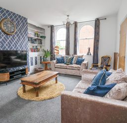 A living room with two sofas a wooden coffee table and television at The Old Station House in Withernsea