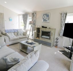 A living room with two sofas a coffee table a television and a fireplace at Olivias Haven in Wemyss Bay