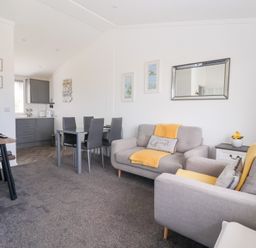 A living room with a sofa and dining area at Bonny Bay in Wilsthorpe near Bridlington