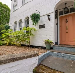 The entrance of Clematis House in St Columb Major with plants and a peach door