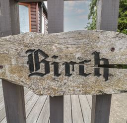 A wooden sign with the word Birch attached to a wooden fence at Birch Swanage