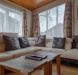 A living room with a sofa and coffee table at Willow in Swanage