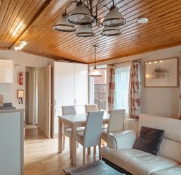 A living room with a kitchen area and a dining table at Willow in Swanage