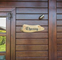 A wooden door with glass panels and a wooden sign that says Cherry at Cherry in Swanage