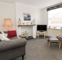A living room with a sofa and television at Bluebell Cottage in Brayton