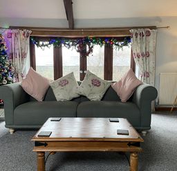 A living room with a sofa and Christmas tree at Foxglove Barn South Brent