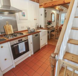 A kitchen with appliances and dining area at Bodillys Cottage Newlyn