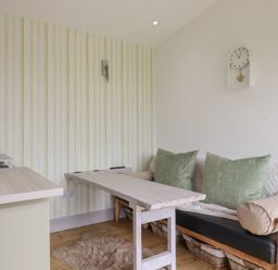 A kitchen with a table and sofa at The Tinystore in Bodmin