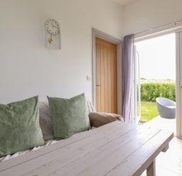A living room with a sofa and a clock at The Tinystore in Bodmin