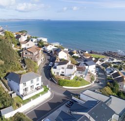 An aerial view of houses and ocean at Looe Island View in Downderry