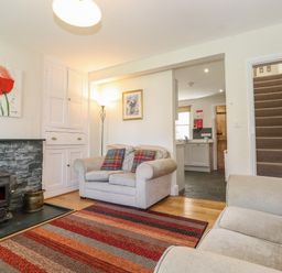 A living room with a wood stove and patterned rug at High Stile in Seatoller near Rosthwaite