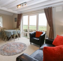 A living room with a table and chairs at Oak Cottage Dinas Dinlle near Caernarfon