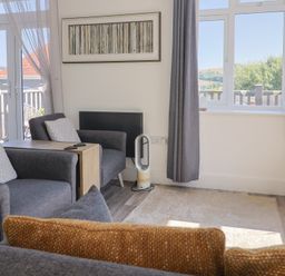 A living room with chairs and a table at Lyme Zest in Lyme Regis
