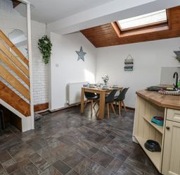 A dining room with a table and chairs at Saddlers Cottage in Weymouth