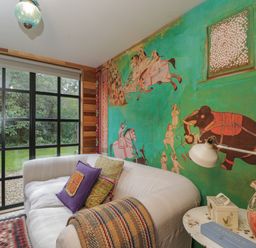 A room with a white sofa and colorful pillows next to a painted wall and a window at The Big Box Brandeers Brandier near Minety