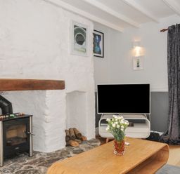 A living room with a television and a fireplace at 3 River View in Looe