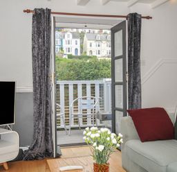 A living room with a TV and a sliding door at 3 River View Looe