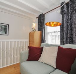 A living room with a sofa and cushions at 3 River View in Looe
