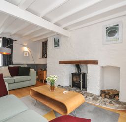 A living room with a sofa and coffee table at 3 River View in Looe