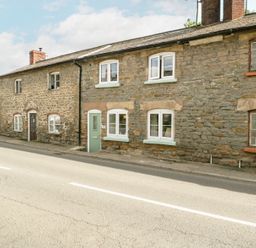 Exterior of stone terraced houses along a curved road at 4 Wallflower Row Mordiford near Hereford