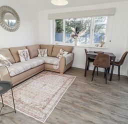 A living room with a sofa and dining table at Old Colliery Cottage in Shilbottle